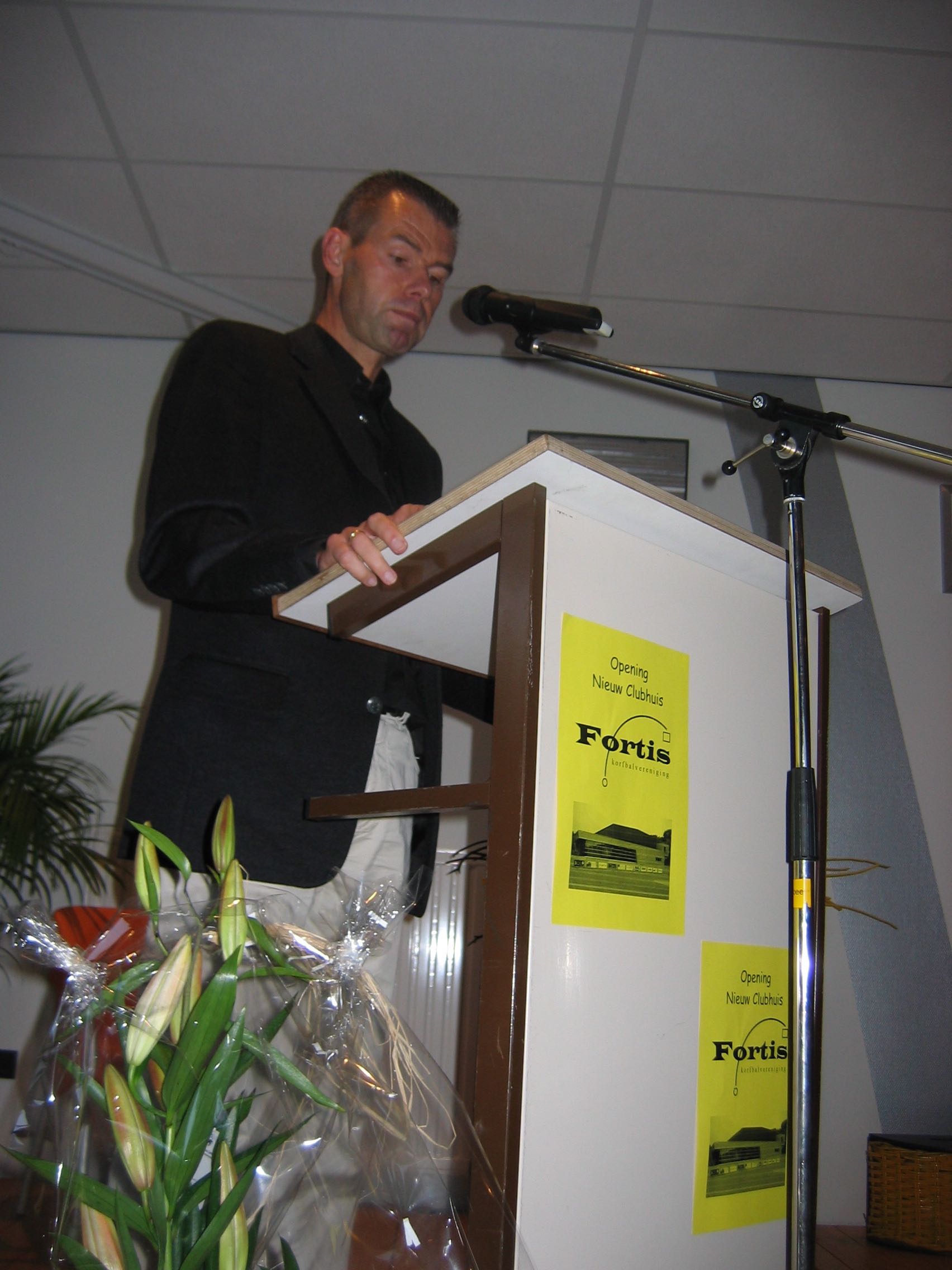 Een spreker staat achter het spreekgestoelte tijdens de opening van het clubhuis.